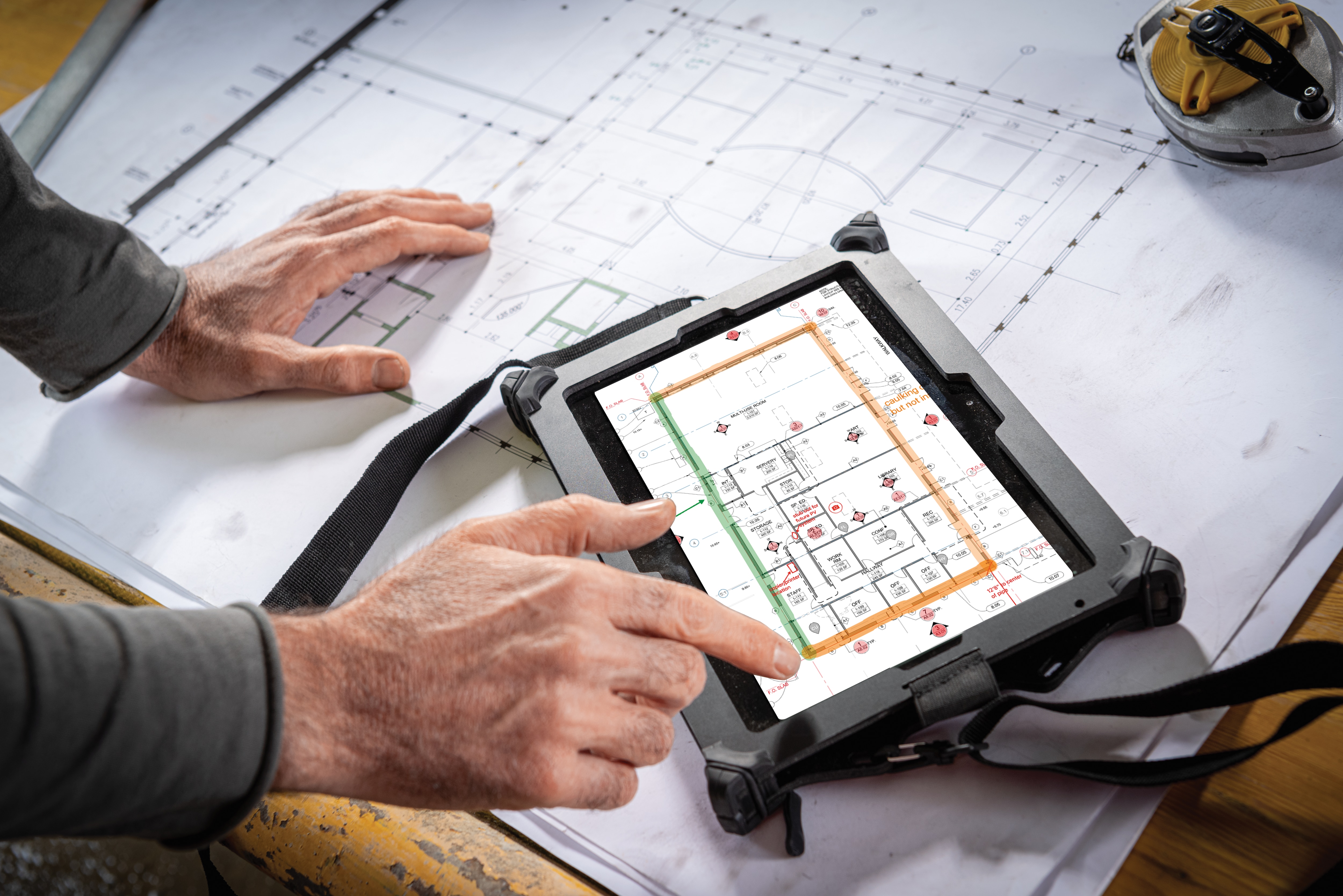 Een man gebruikt de fieldwire-oplossing op zijn tablet op een werf 