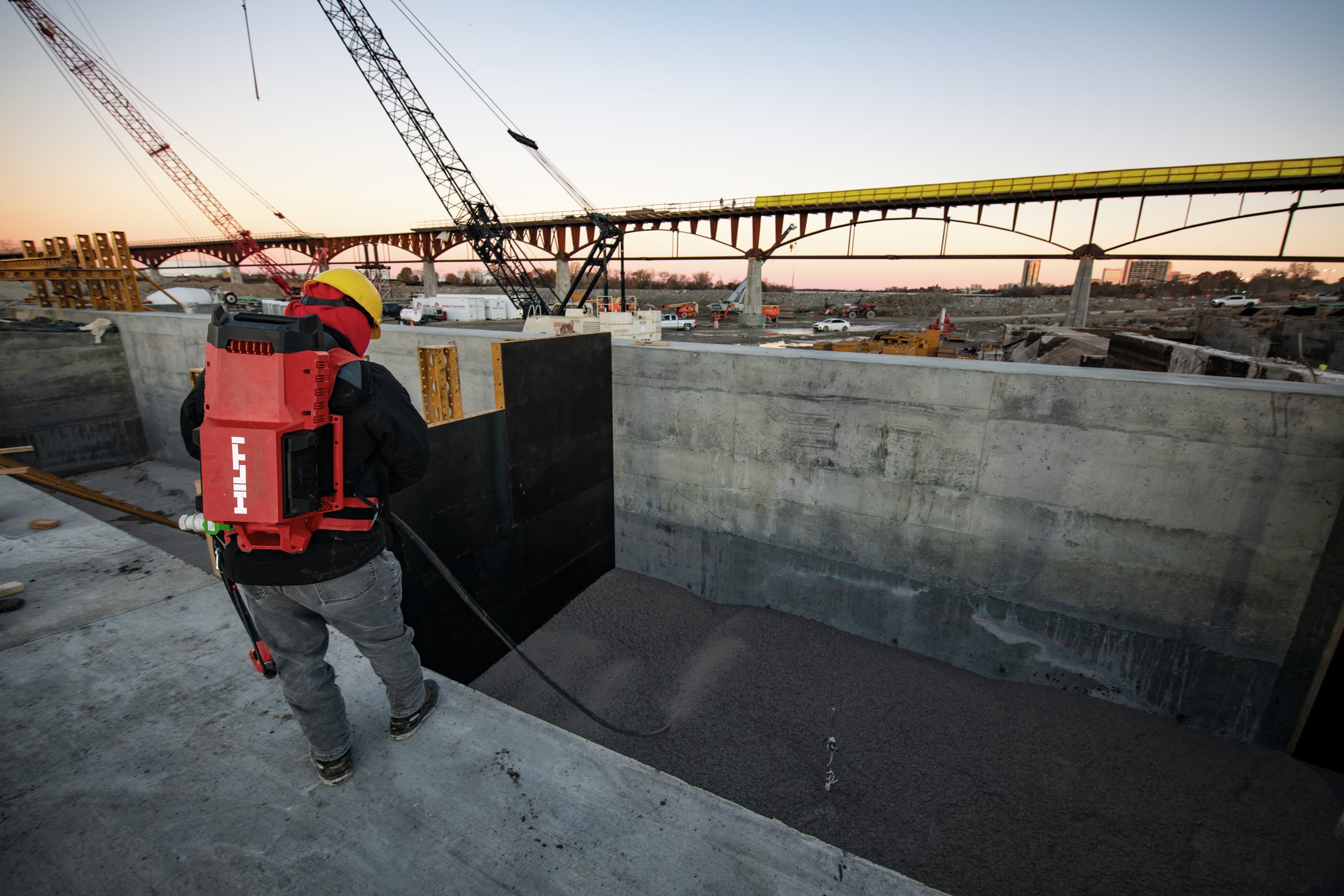 Un employé vibre du béton sur un chantier de construction avec le vibreur à béton NCV 10-22