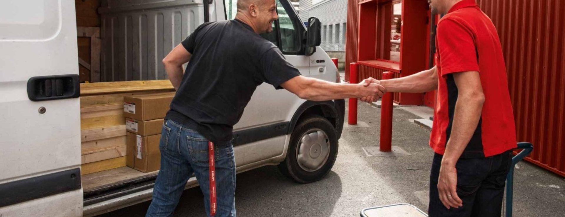 Un client et un employé Hilti se serrent la main devant une camionnette
