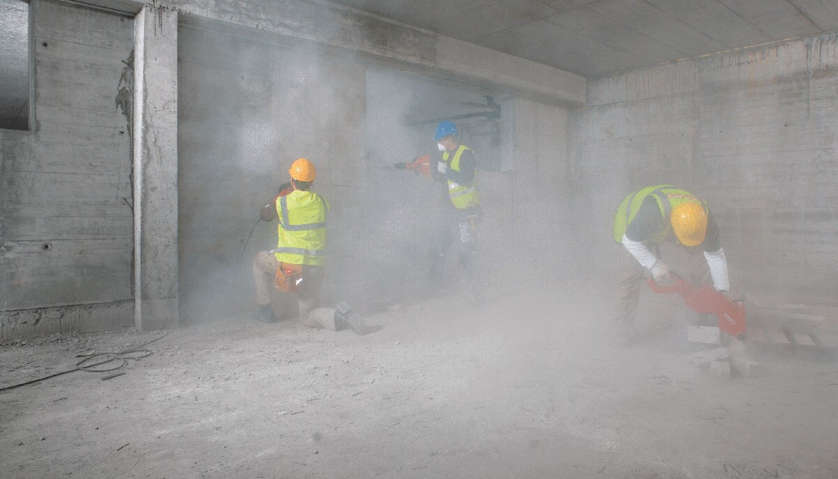 3 mannen werken in het stof op een werf