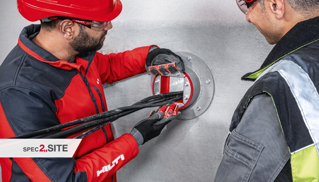 Een Hilti veldingenieur toont een klant een brandwerende huls in een elektrische toepassing