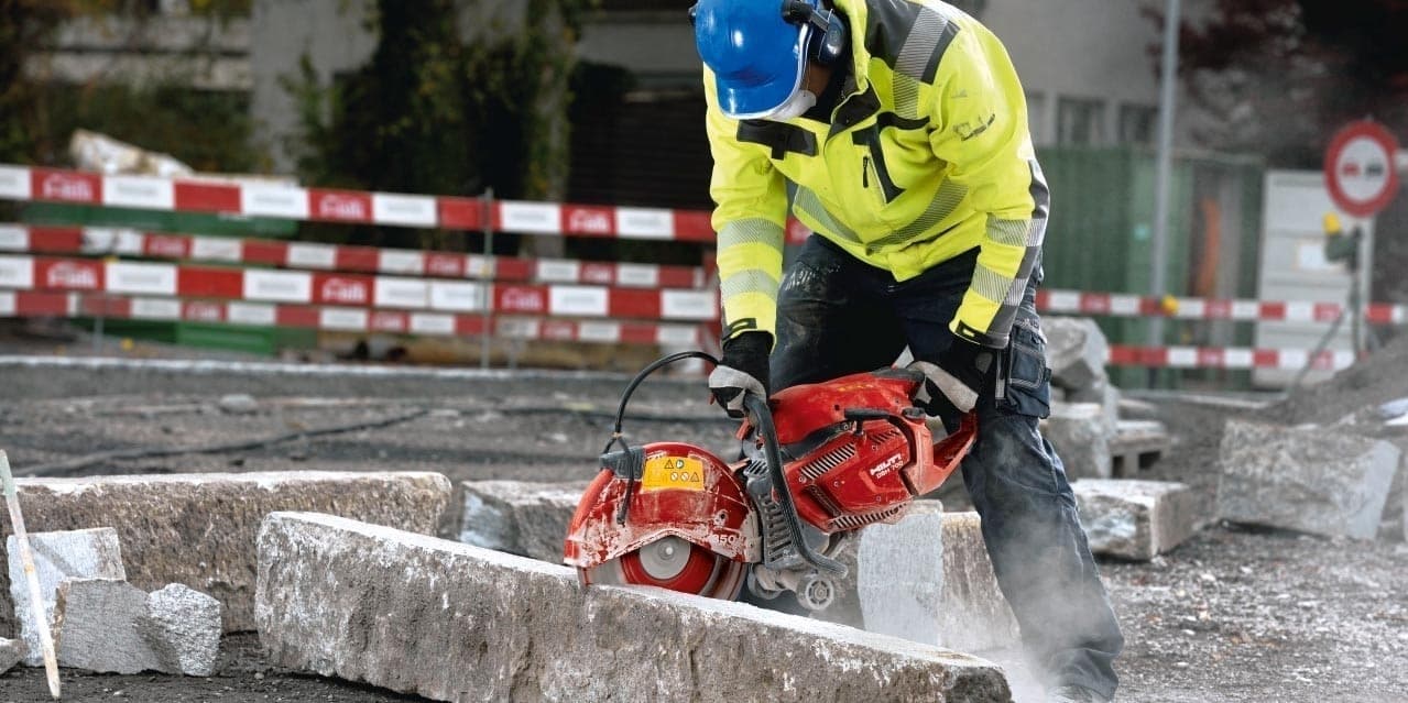 Découpe de bordure de trottoir à l'aide d'une tronçonneuse thermique